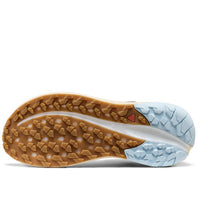 Close-up of a shoe sole with brown tread pattern and light blue outsole on a white background